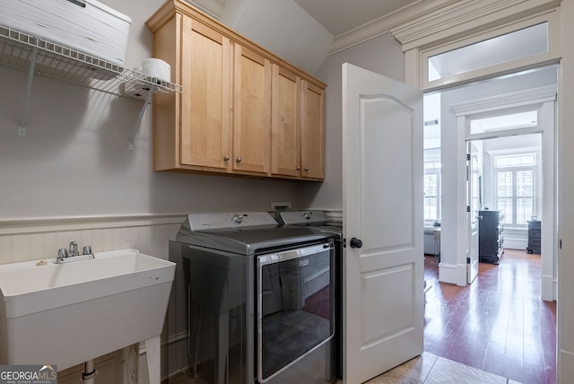 washroom with sink, cabinets, light wood-type flooring, washer and clothes dryer, and ornamental molding