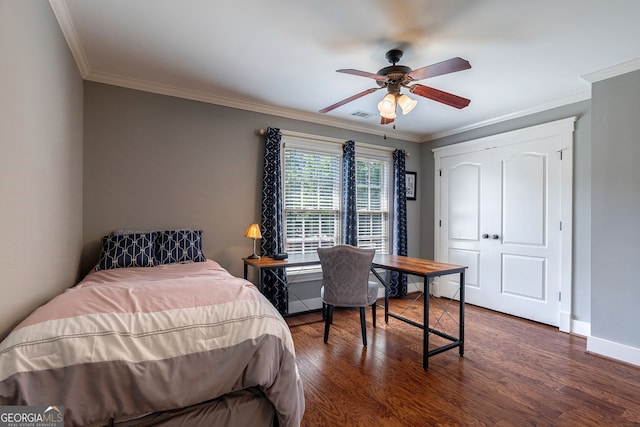 bedroom with ceiling fan, a closet, dark wood-type flooring, and ornamental molding