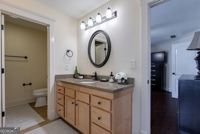 bathroom with hardwood / wood-style floors, vanity, and toilet