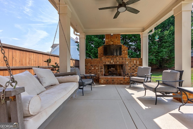 view of patio with an outdoor living space with a fireplace and ceiling fan