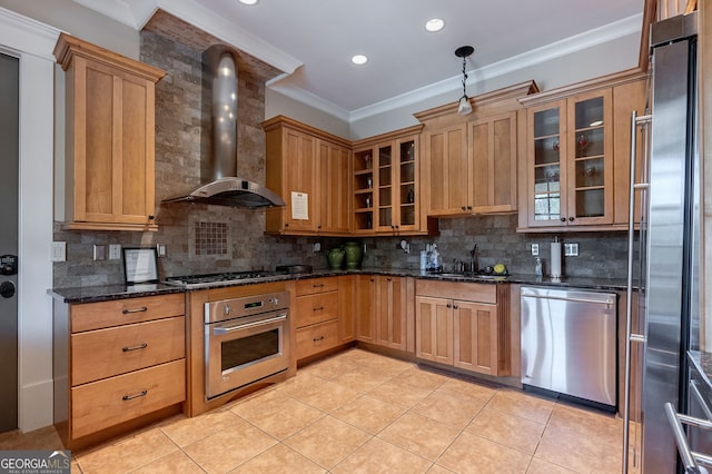 kitchen featuring tasteful backsplash, stainless steel appliances, sink, wall chimney range hood, and pendant lighting