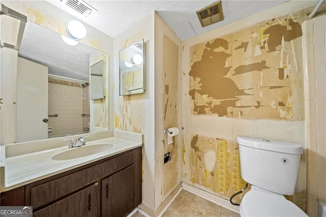 bathroom with vanity, a textured ceiling, toilet, and tile patterned flooring