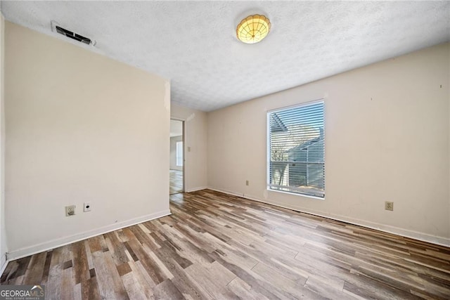 empty room featuring hardwood / wood-style floors and a textured ceiling