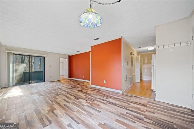 unfurnished living room with light hardwood / wood-style floors and ornamental molding