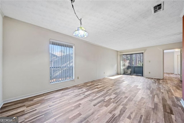 unfurnished living room featuring light hardwood / wood-style floors and a textured ceiling