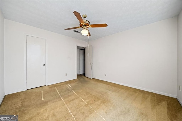 unfurnished bedroom featuring carpet, ceiling fan, and a textured ceiling