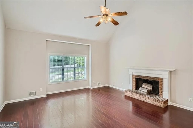 unfurnished living room with ceiling fan, dark hardwood / wood-style floors, vaulted ceiling, and a brick fireplace