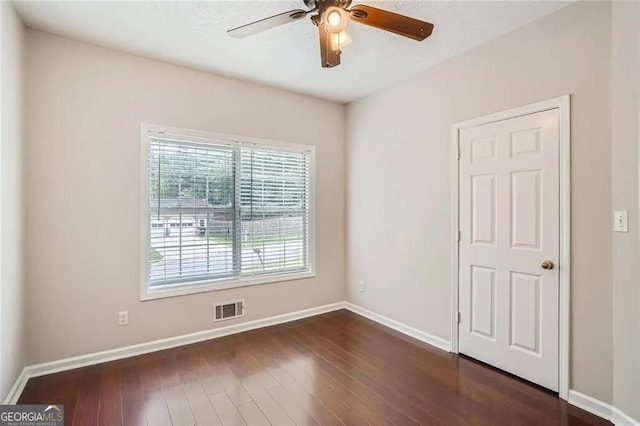 spare room featuring dark hardwood / wood-style floors and ceiling fan