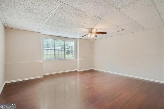 empty room with dark hardwood / wood-style flooring, ceiling fan, and a paneled ceiling