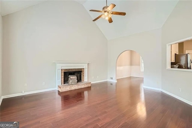 unfurnished living room with ceiling fan, dark hardwood / wood-style flooring, a fireplace, and high vaulted ceiling