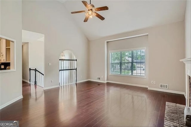 unfurnished living room featuring a fireplace, dark hardwood / wood-style flooring, high vaulted ceiling, and ceiling fan