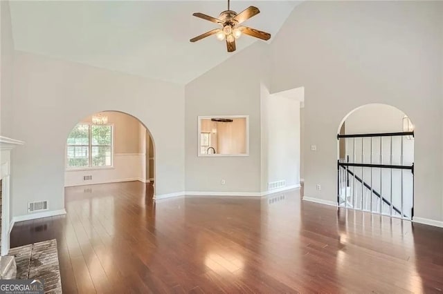 unfurnished living room featuring a fireplace, high vaulted ceiling, ceiling fan, and dark wood-type flooring