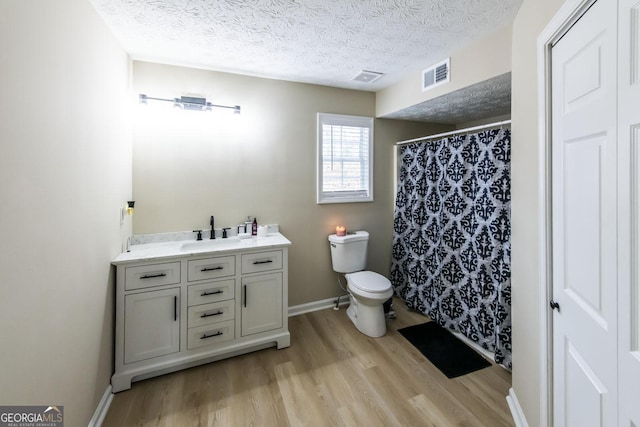 bathroom featuring a textured ceiling, toilet, hardwood / wood-style flooring, vanity, and a shower with shower curtain