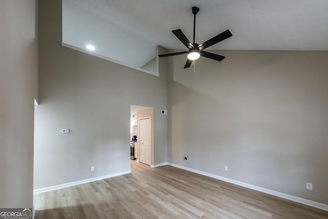 empty room with light wood-type flooring, high vaulted ceiling, and ceiling fan