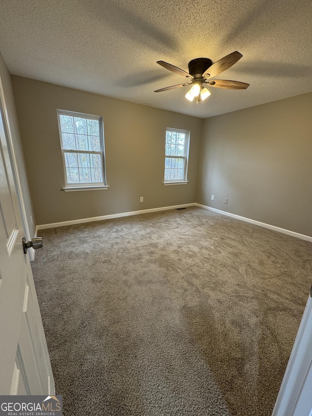 empty room featuring carpet flooring, a textured ceiling, plenty of natural light, and ceiling fan