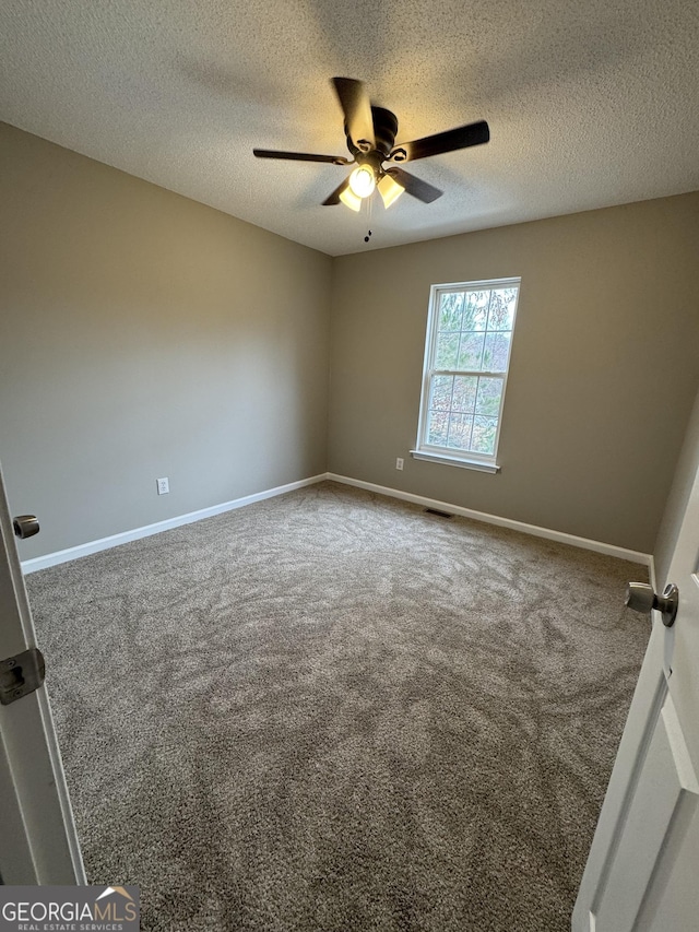 carpeted empty room featuring a textured ceiling