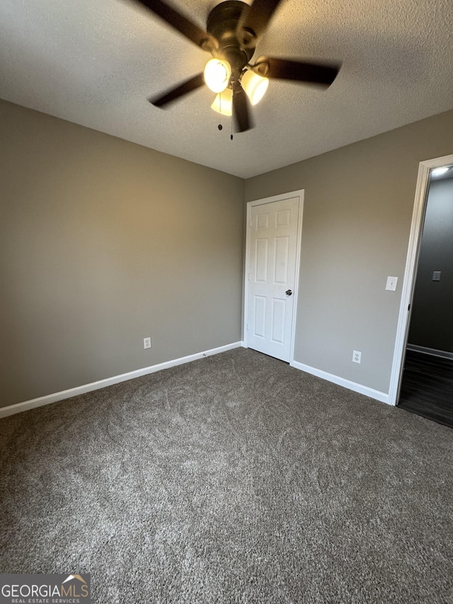 unfurnished bedroom with dark colored carpet, a textured ceiling, and ceiling fan