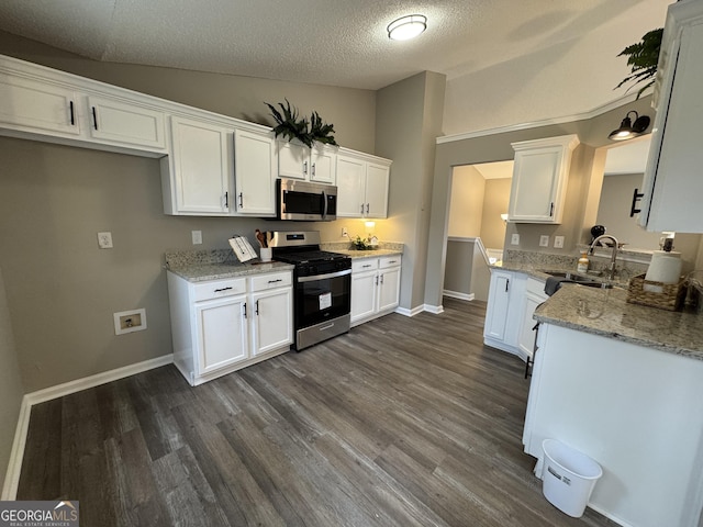 kitchen featuring appliances with stainless steel finishes, a textured ceiling, white cabinetry, and sink