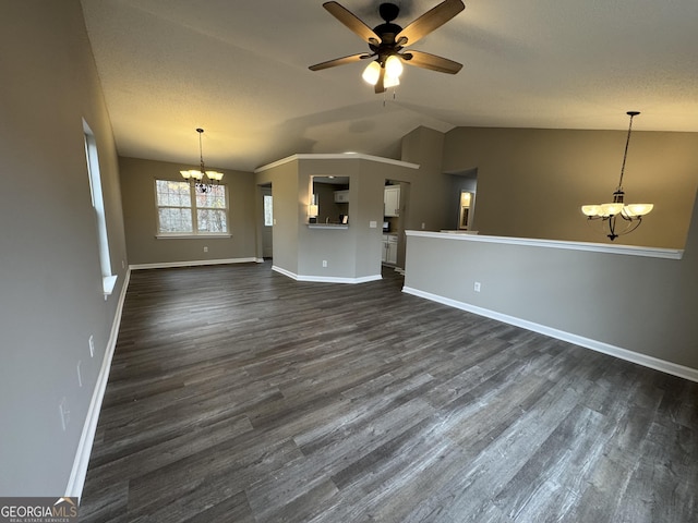 unfurnished living room featuring ceiling fan with notable chandelier, dark hardwood / wood-style flooring, and lofted ceiling