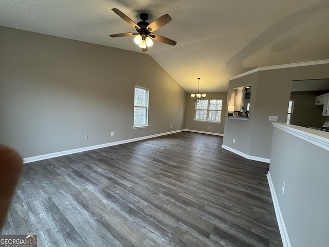 unfurnished living room featuring ceiling fan with notable chandelier, dark hardwood / wood-style flooring, and lofted ceiling