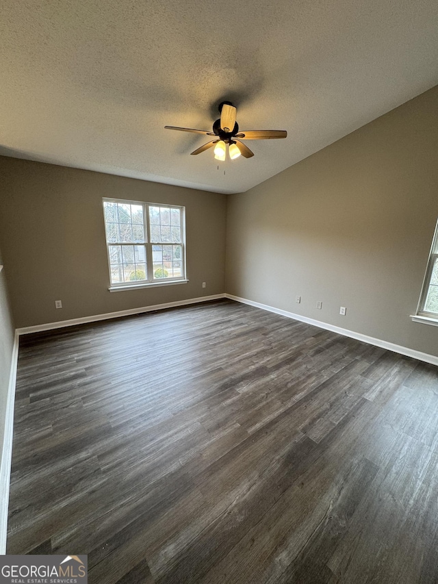 unfurnished room featuring ceiling fan, a textured ceiling, and dark wood-type flooring