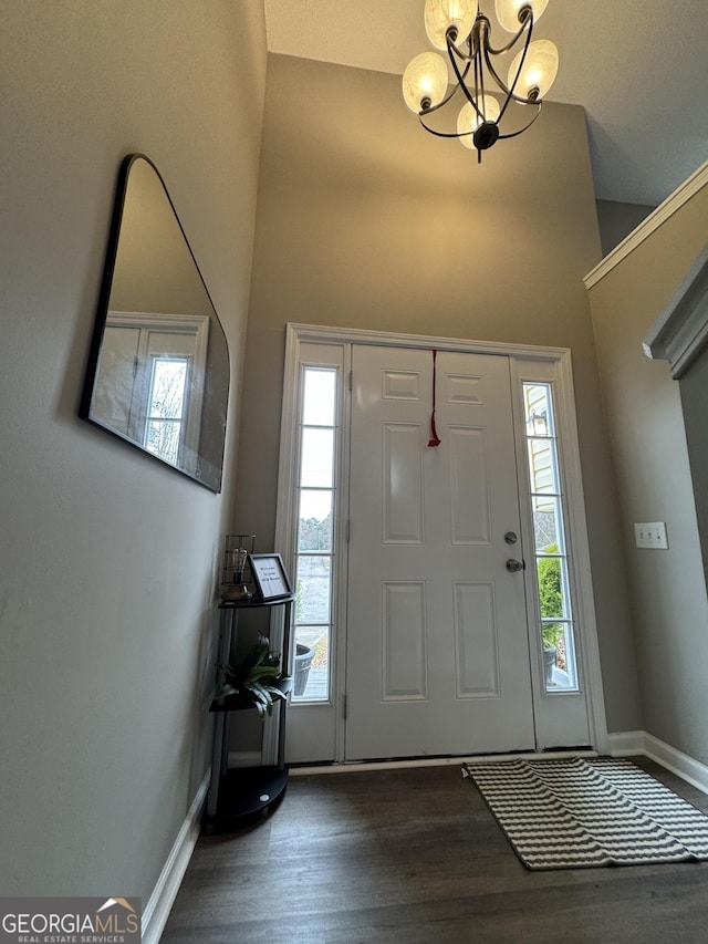 entrance foyer featuring dark hardwood / wood-style floors, a towering ceiling, and a chandelier