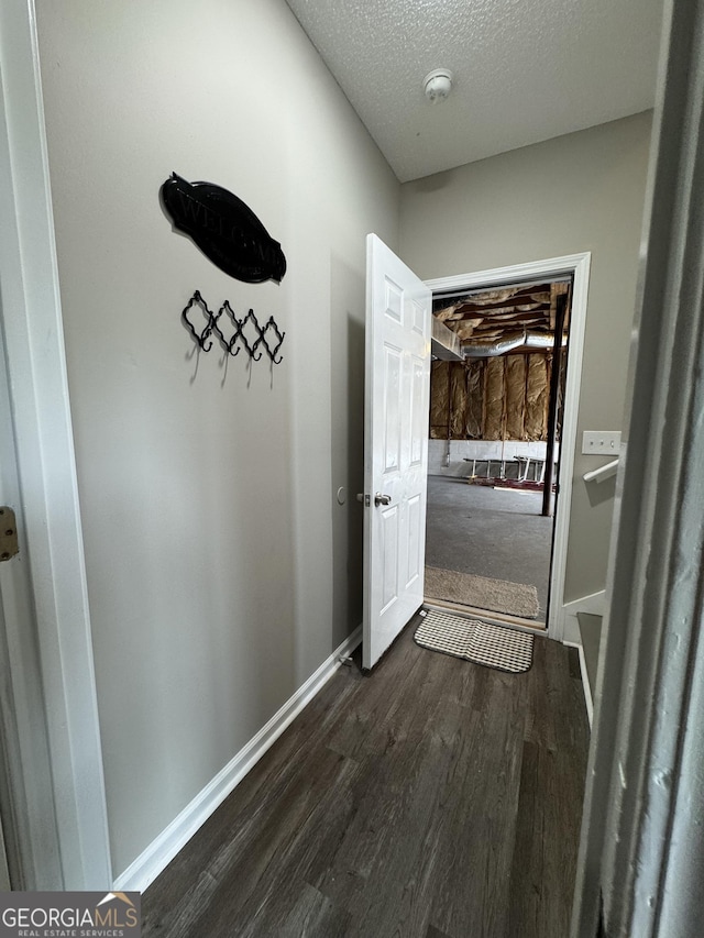 hallway featuring dark hardwood / wood-style floors and a textured ceiling