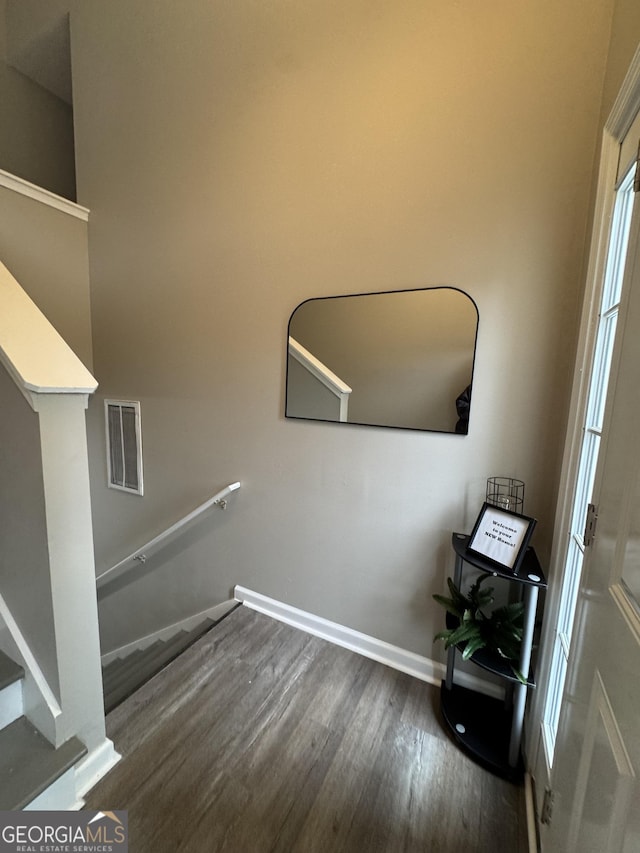 stairway featuring wood-type flooring and a wealth of natural light