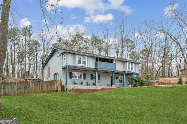 rear view of property with a patio and a lawn