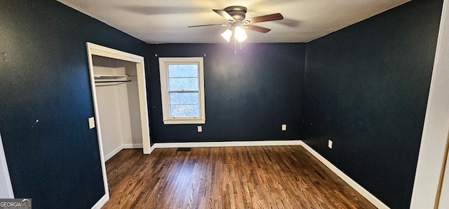 unfurnished bedroom featuring ceiling fan, a closet, and dark wood-type flooring