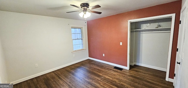 unfurnished bedroom with dark wood-type flooring, ceiling fan, and a closet