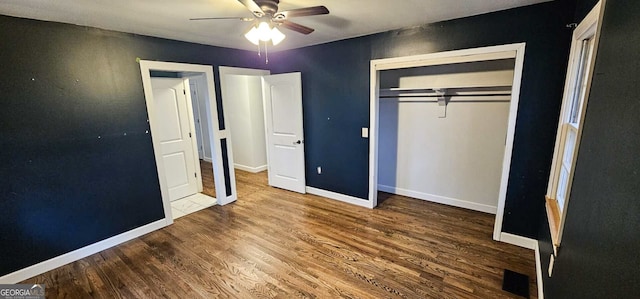 unfurnished bedroom with ceiling fan, wood-type flooring, and a closet