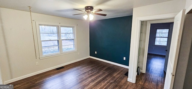 spare room featuring dark wood-type flooring and ceiling fan