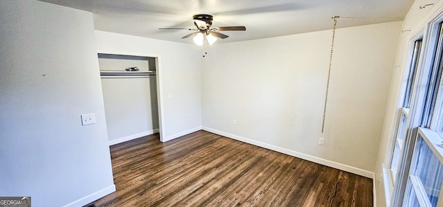 unfurnished bedroom with dark wood-type flooring, ceiling fan, and a closet