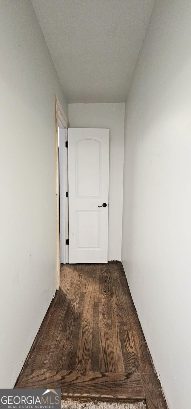 corridor with dark hardwood / wood-style flooring