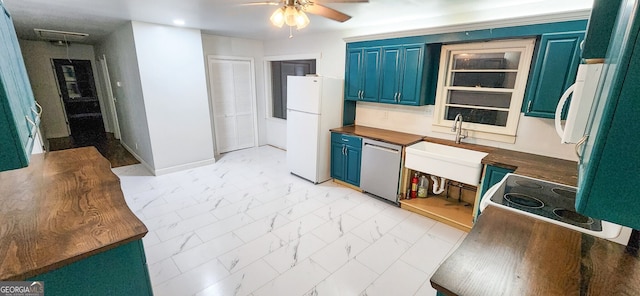 kitchen with blue cabinetry, dishwasher, white refrigerator, and sink