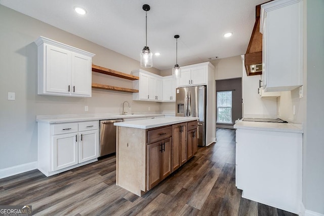 kitchen with appliances with stainless steel finishes, dark hardwood / wood-style flooring, white cabinetry, and pendant lighting