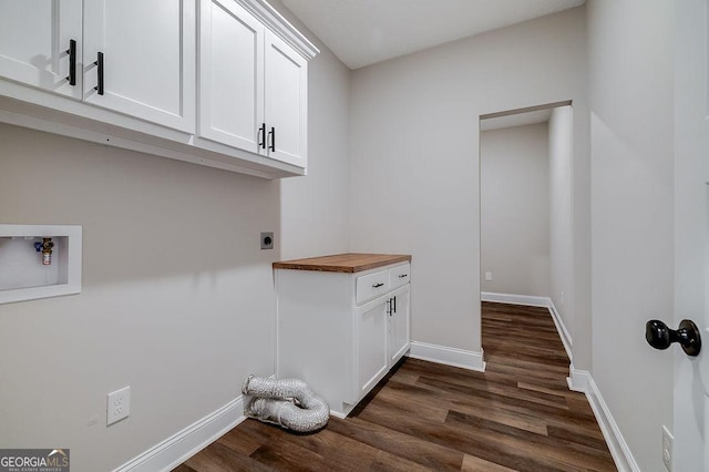 washroom with hookup for an electric dryer, hookup for a washing machine, dark hardwood / wood-style flooring, and cabinets