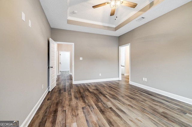 spare room with dark hardwood / wood-style flooring, a tray ceiling, ceiling fan, and crown molding