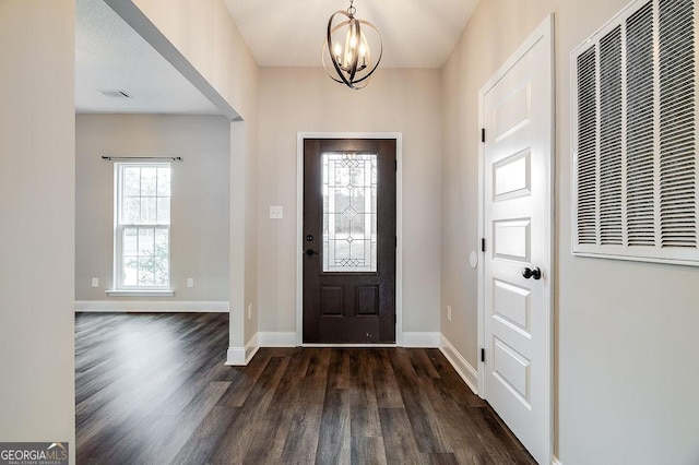 entryway featuring dark hardwood / wood-style flooring and an inviting chandelier