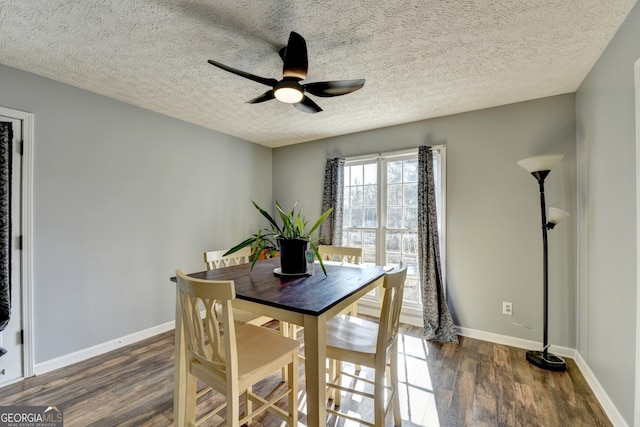 dining area featuring ceiling fan, dark wood-type flooring, and a textured ceiling