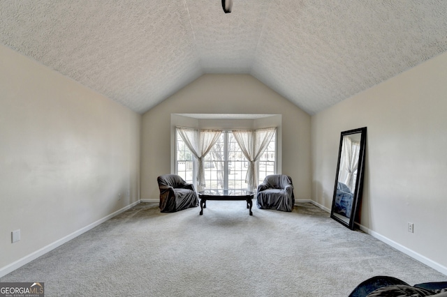 sitting room featuring carpet flooring, a textured ceiling, and vaulted ceiling