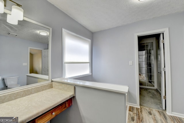 bathroom featuring hardwood / wood-style floors, toilet, and a textured ceiling