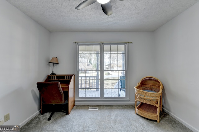 sitting room featuring ceiling fan, carpet, and a textured ceiling