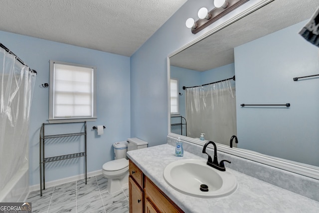 full bathroom with a wealth of natural light, vanity, a textured ceiling, and toilet