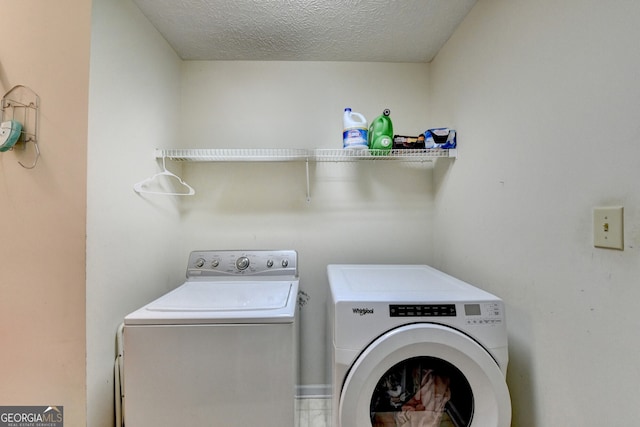 laundry area with washer and clothes dryer and a textured ceiling