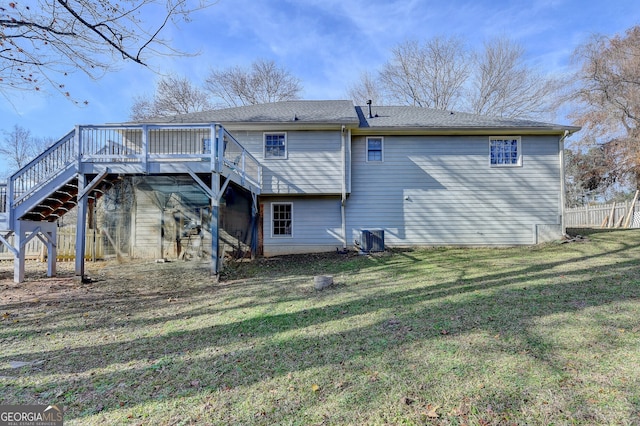 back of property with central air condition unit, a deck, and a lawn