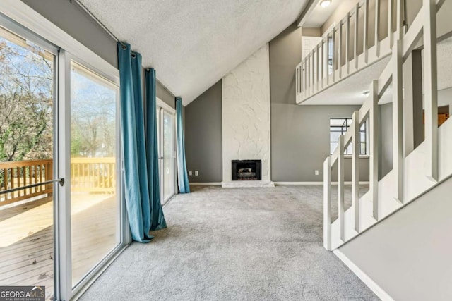 carpeted living room with a fireplace, a textured ceiling, and lofted ceiling