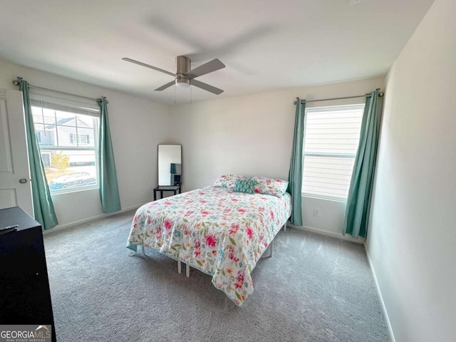 bedroom with ceiling fan, light carpet, and multiple windows