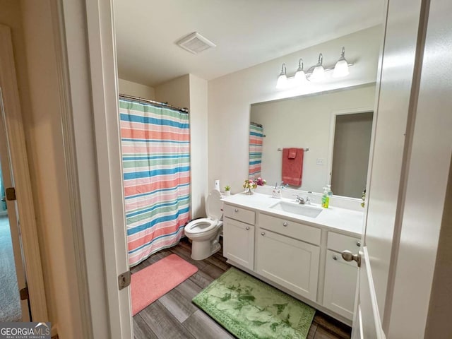 bathroom featuring hardwood / wood-style floors, vanity, toilet, and a shower with curtain